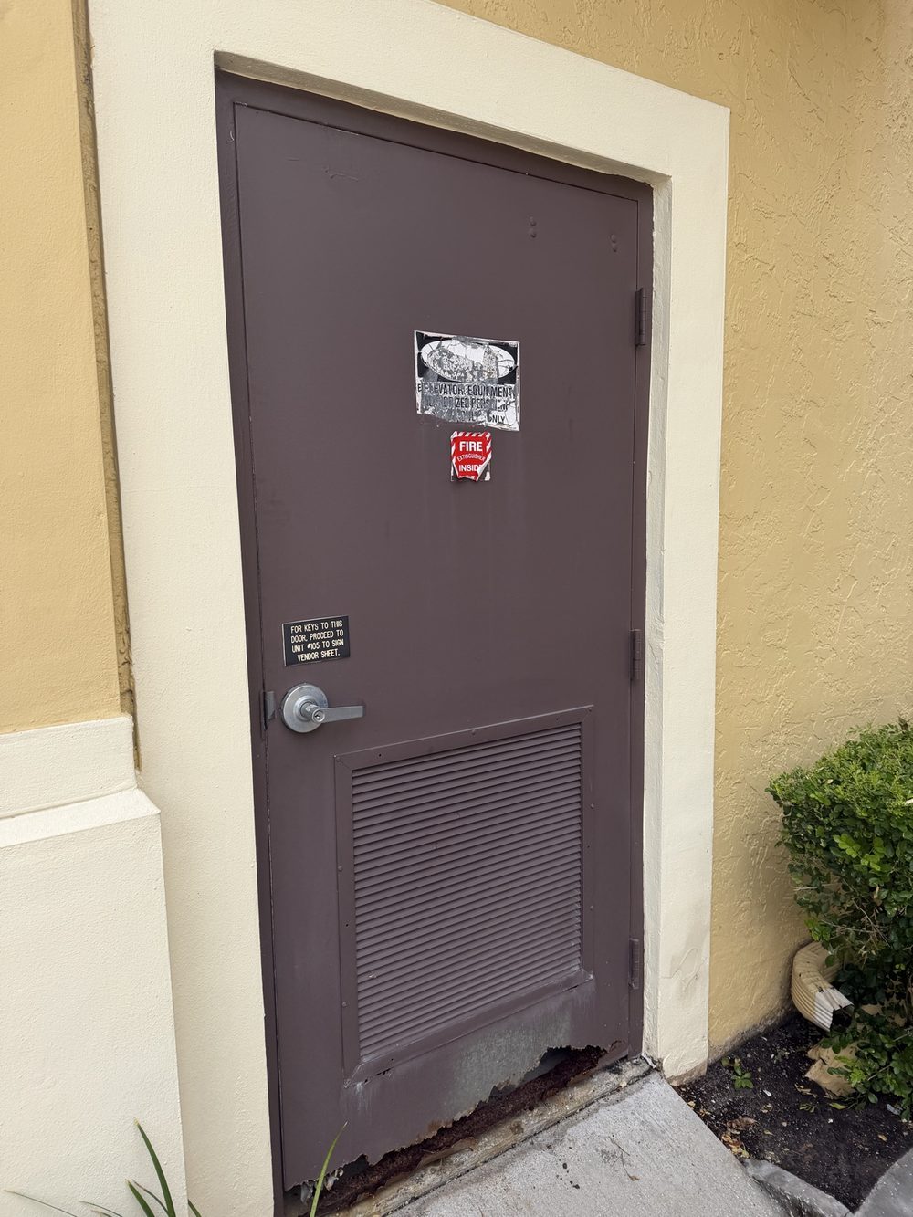 Rusted fire-rated metal door before replacement